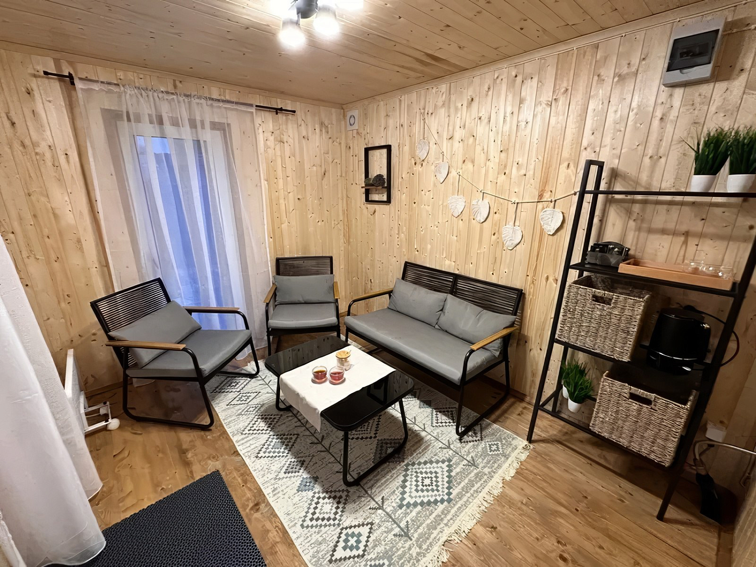 Лаунж-зона Амелия с диваном и креслами в чёрно-сером цвете: три локации, один характер — графичная элегантность среди деревьев, на мощёной площадке и в интерьере деревянного дома